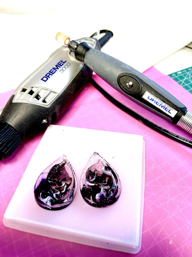 Showing a Dremel multi tool with a flexible shaft attached - and two resin pieces below
