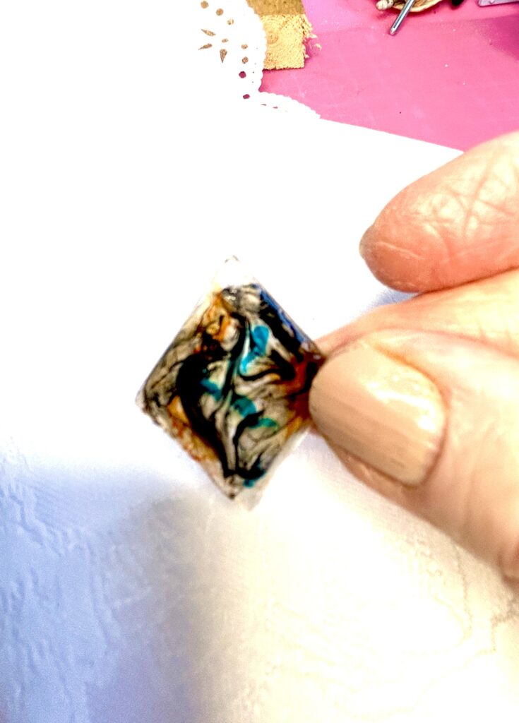 Thumb and forefinger holding a piece of cured resin