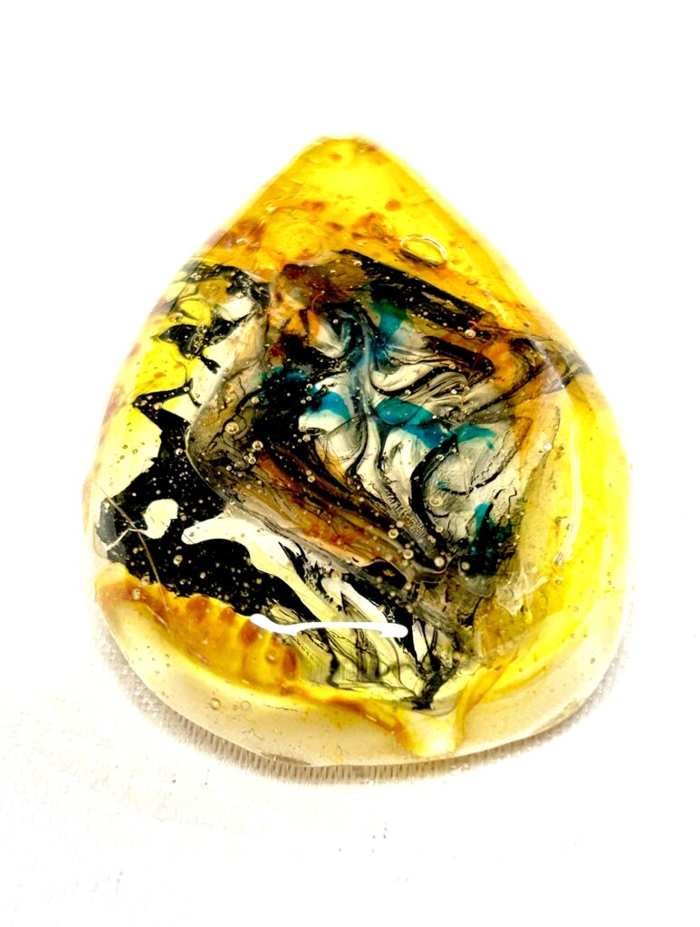 very shiny mainly yellow in colour pendant made with resin
