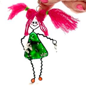 Mary-Anne character bag charm titled DIY Kate with shocking pink hair tied in bunches and a hand drill in one hand and screwdriver in the other wearing a green dress that looks like stained glass hand painted facial features