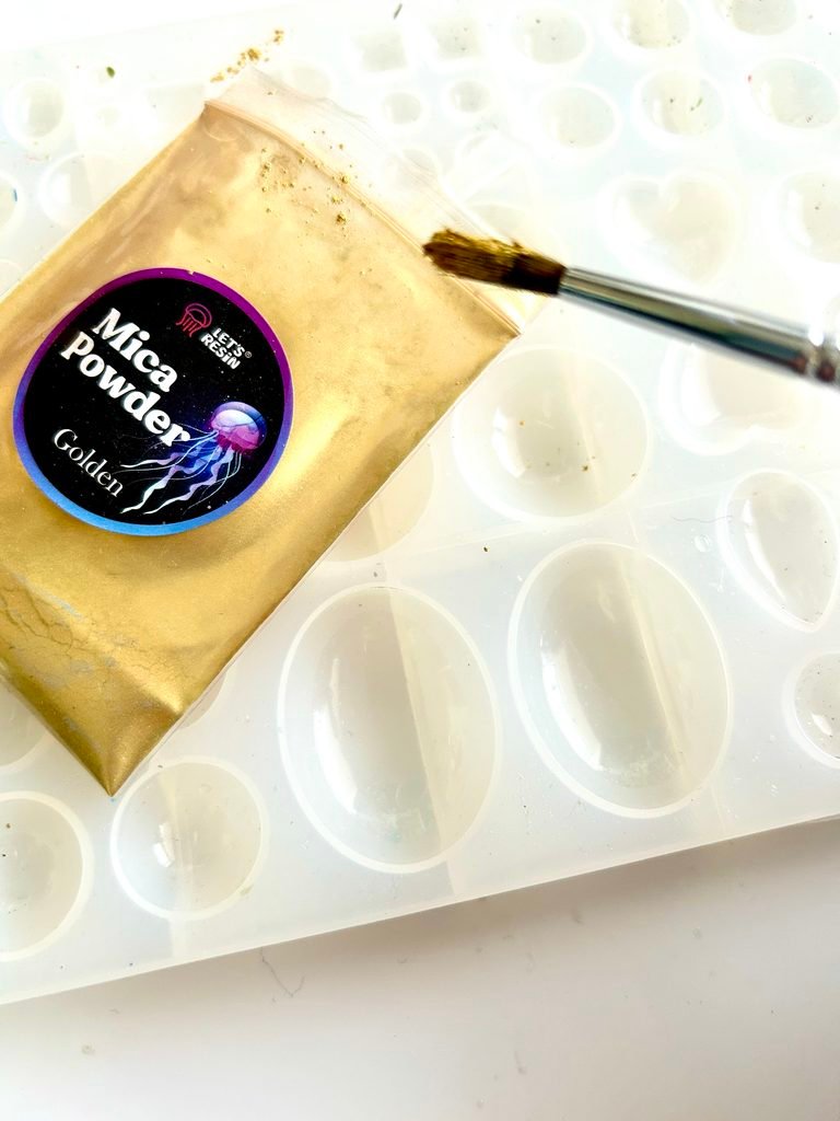 packet of gold mica powder with a paint brush ready to be brushed into the silicon mould